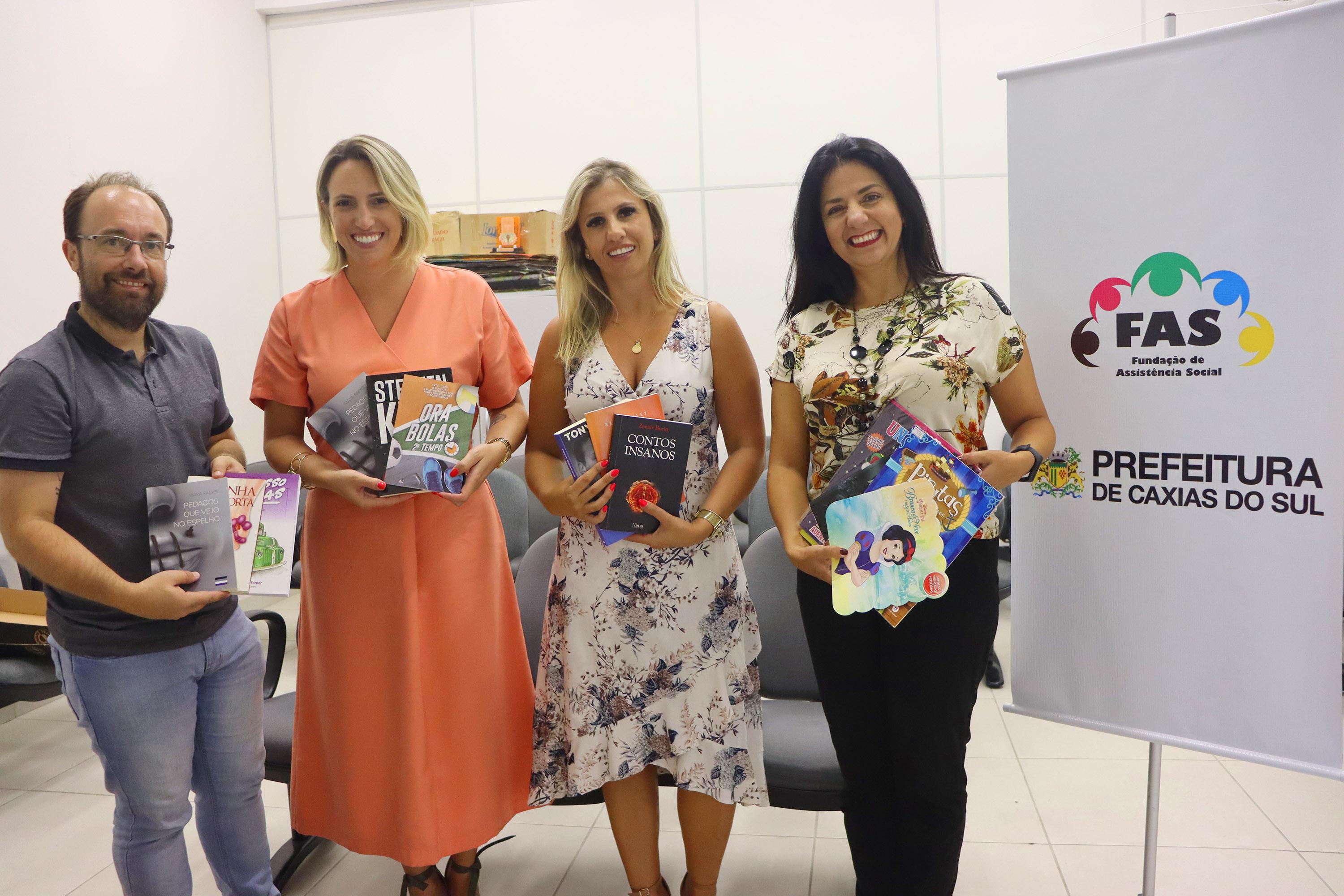 Marisol Santos e Felipe Gremelmaier entregam livros arrecadados para a FAS